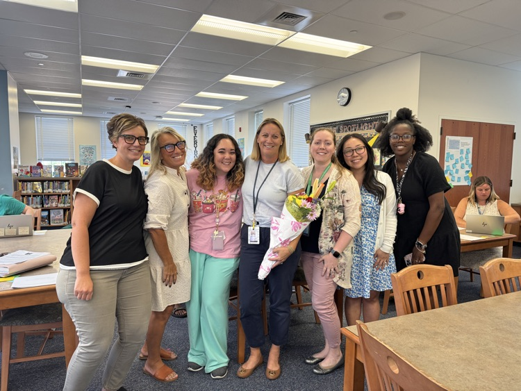 smiling teachers with a nominee holding flowers