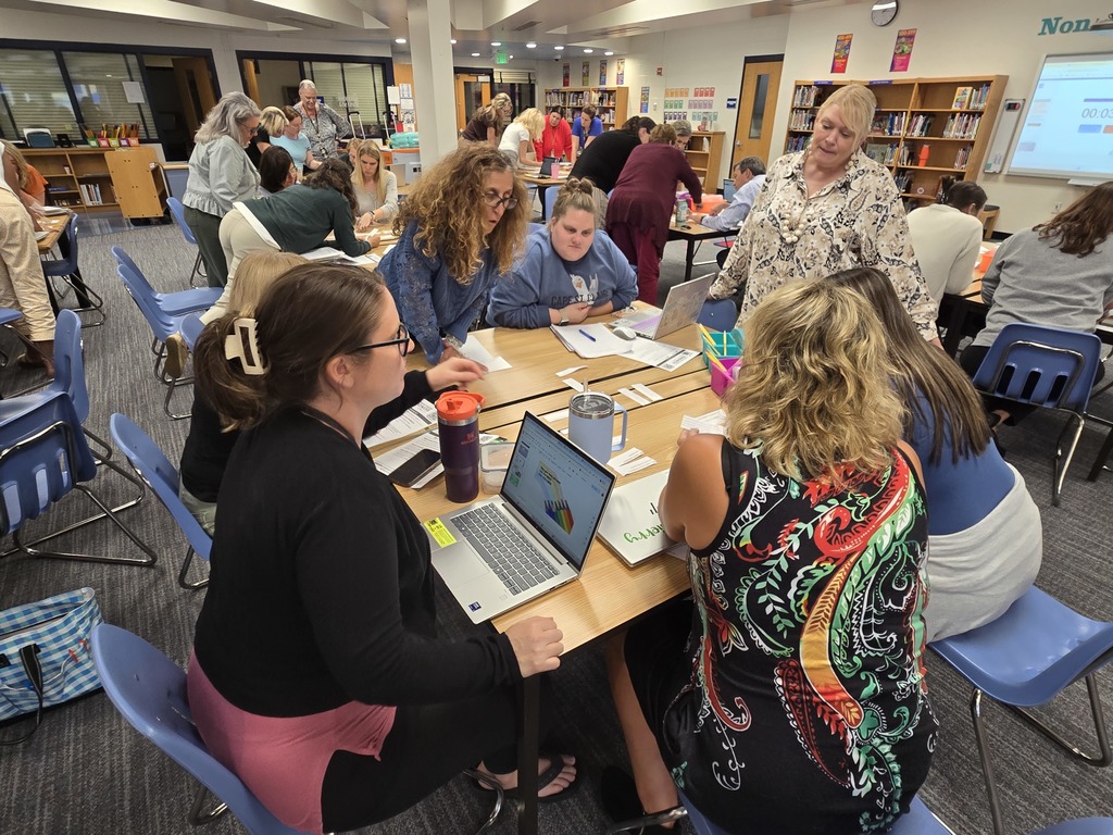 Teachers working and talking at a table.