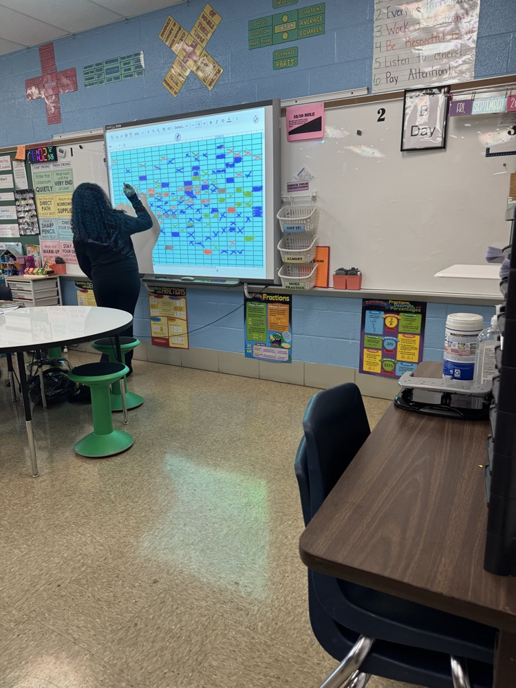 student marking battleship board 