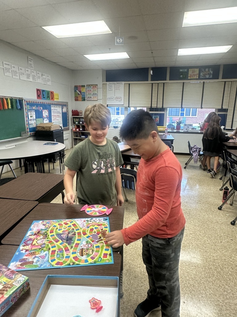 Two boys standing while playing  a board game.