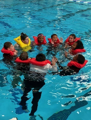 5th grade group in the water learning to swim.