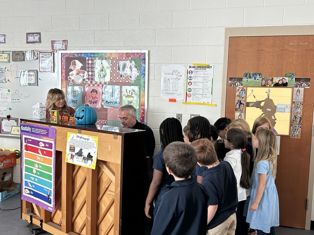Signore Longo plays the piano during a music class for students.