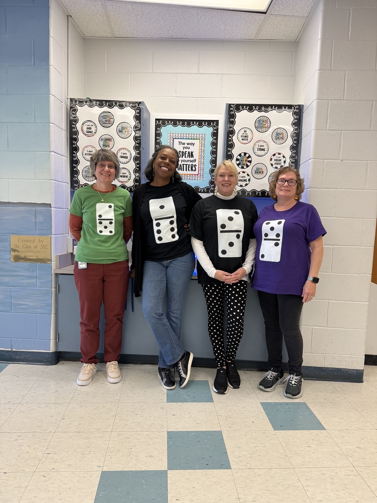 Four women in t-shirts with dominoes on the front.