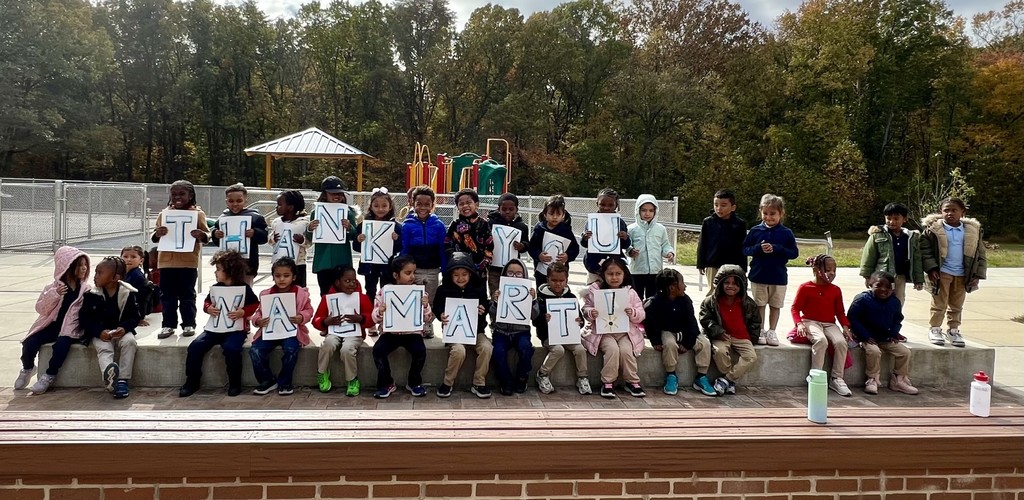 Prek students holding up a sign that reads "Thank you Walmart"