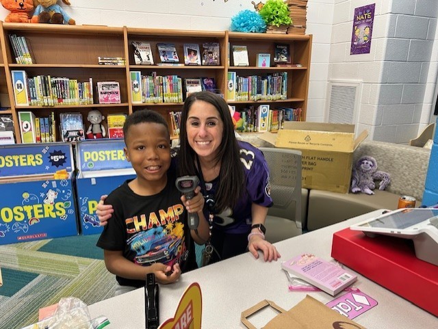 Student and teacher in media center during book fair