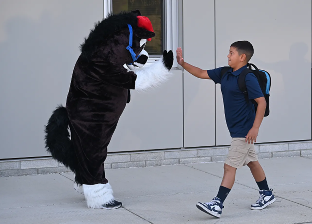 Student giving a high five to our school mascot (horse)