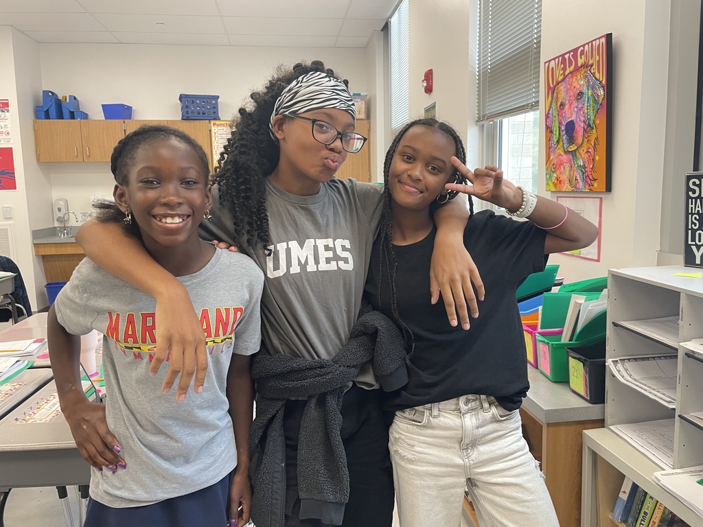 Three 5th grade students hugging