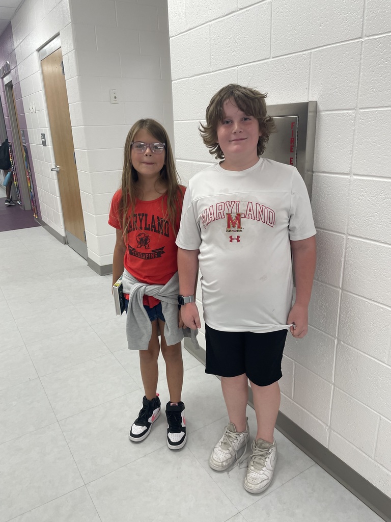 Two 4th graders posing in the hallway