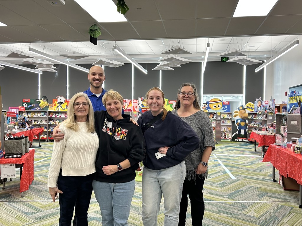 Photo of volunteers at book fair in media center.