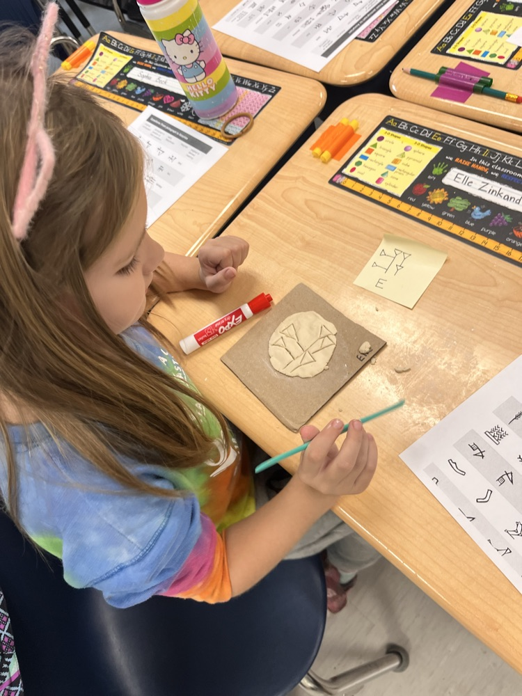 student sculpting clay