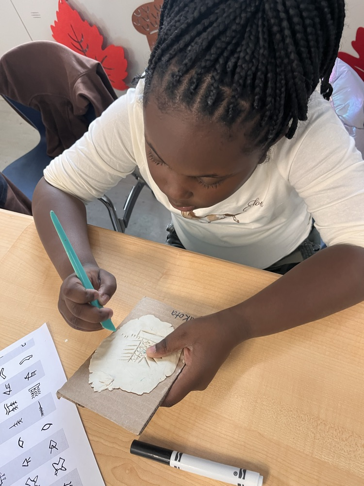 student sculpting clay