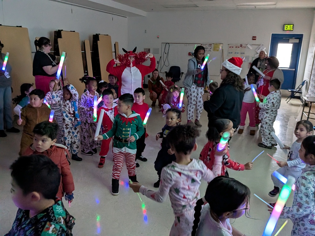 Children dancing with Dinky, the school mascot
