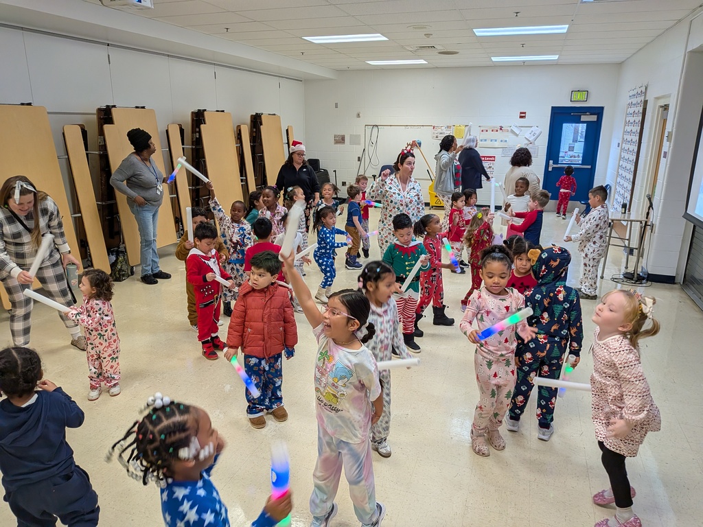 Children dancing with Dinky, the school mascot
