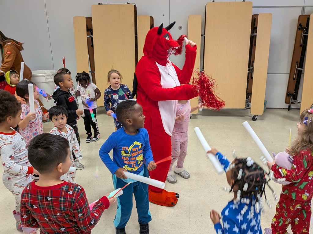 Children dancing with Dinky, the school mascot