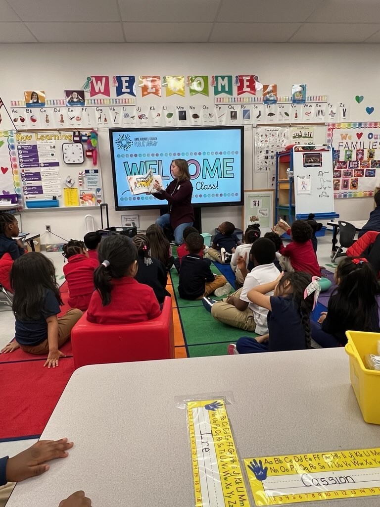 LIbrarian reading a book to students