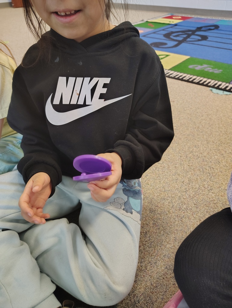 students holding a purple castenet