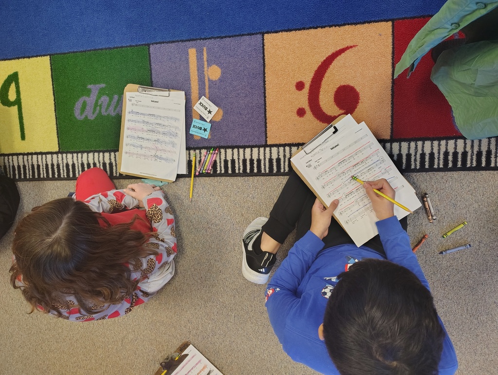 students with clipboards working on a music rug