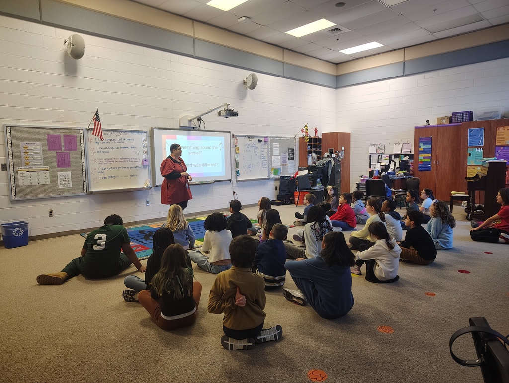 students sitting and while the teacher is in the front of the room teaching