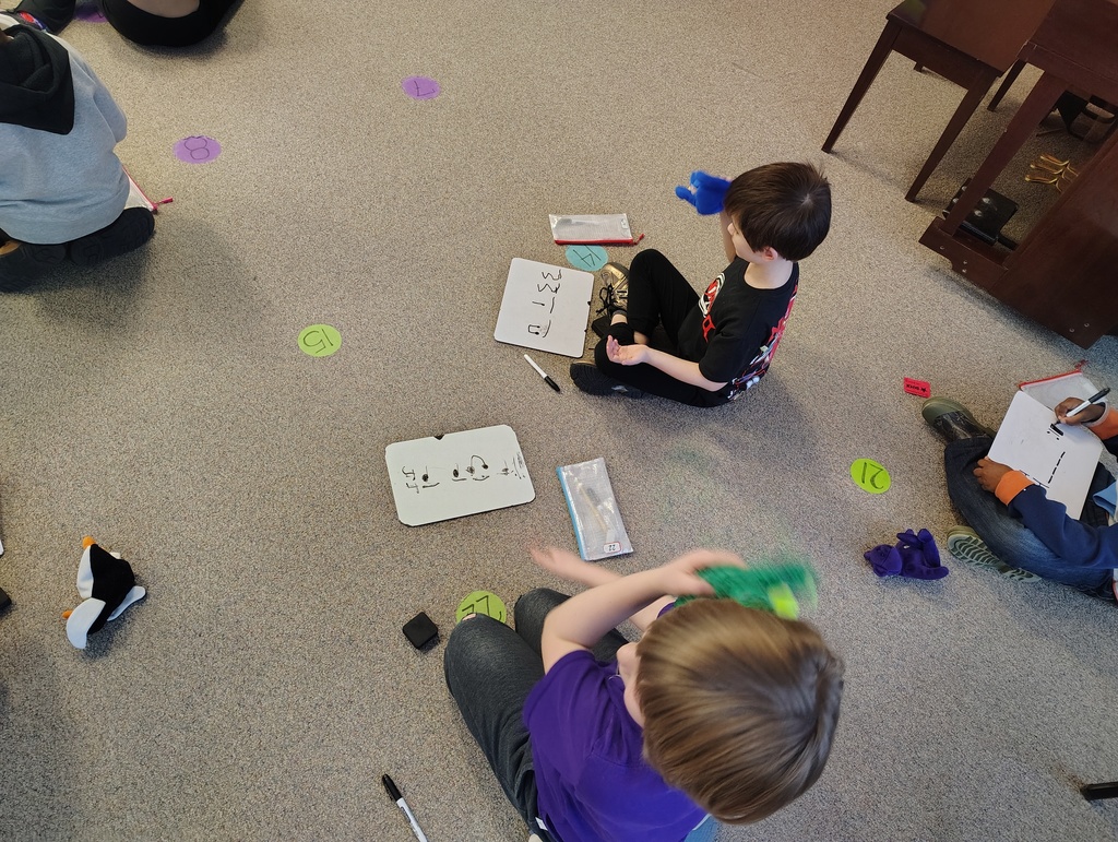 students with whiteboards writing music rhythms