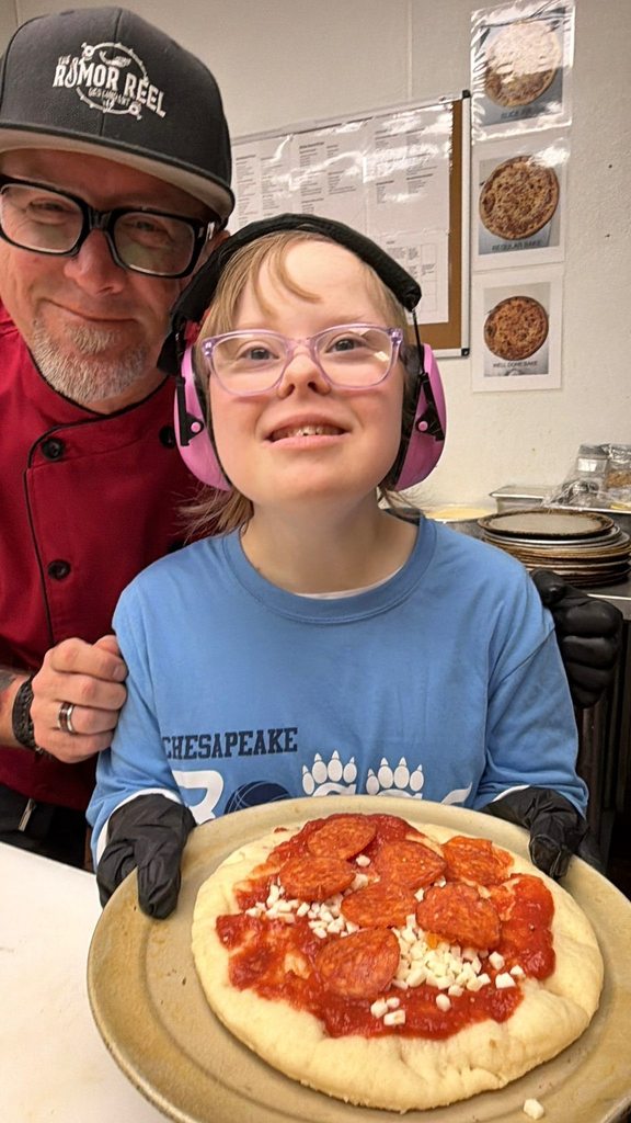 Student and Rumor Meal staff member with homemade pizza