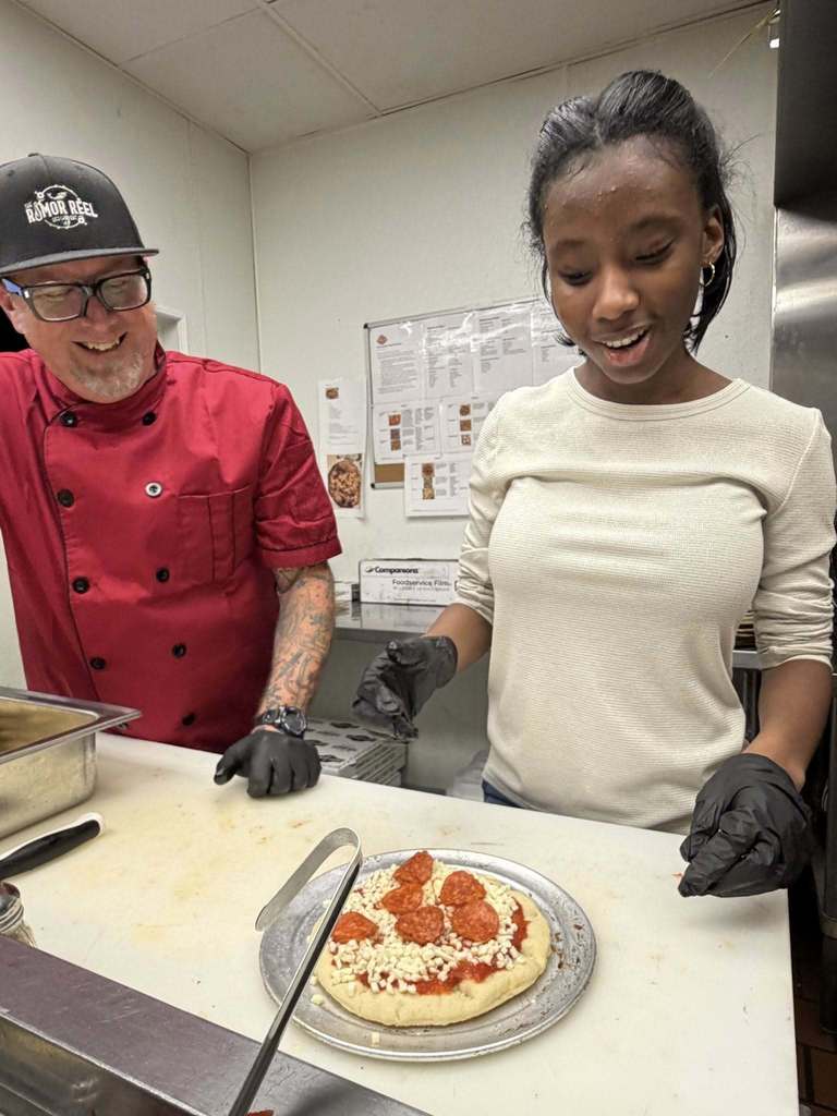 Student making pizza at The Rumor Meal restaurant