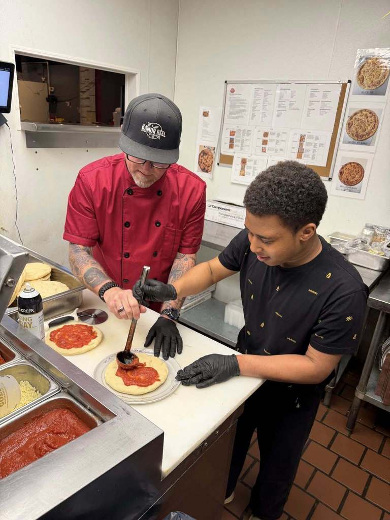 Student making pizza at The Rumor Meal restaurant