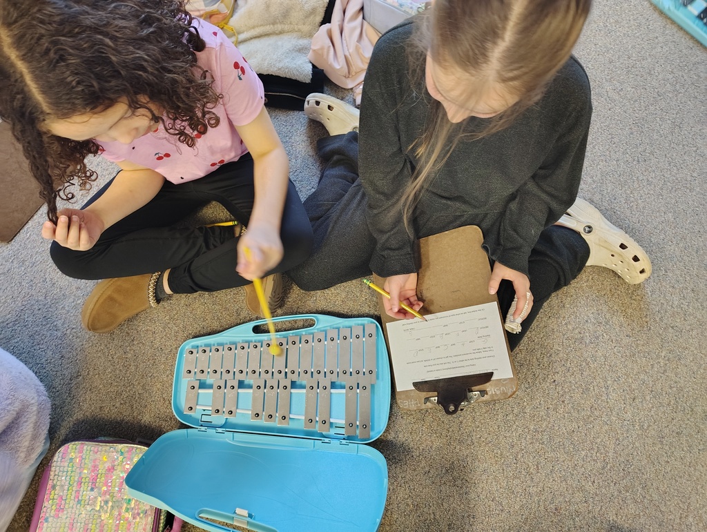 2 girls, blue and silver glockenspiel, clipboard and paper