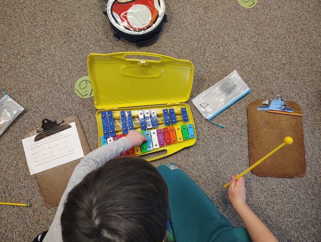 a student pointing to a note on a color-coded xylophone