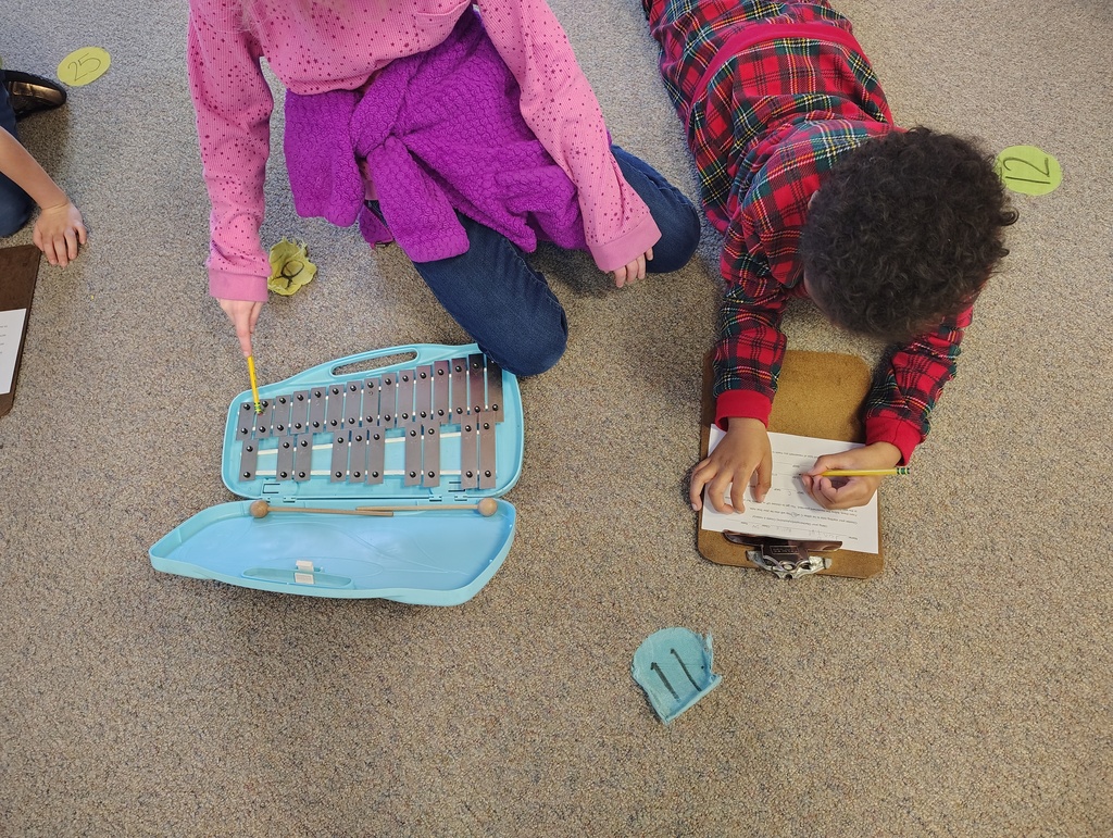2 students, blue and silver glockenspiel, clipboard and worksheet