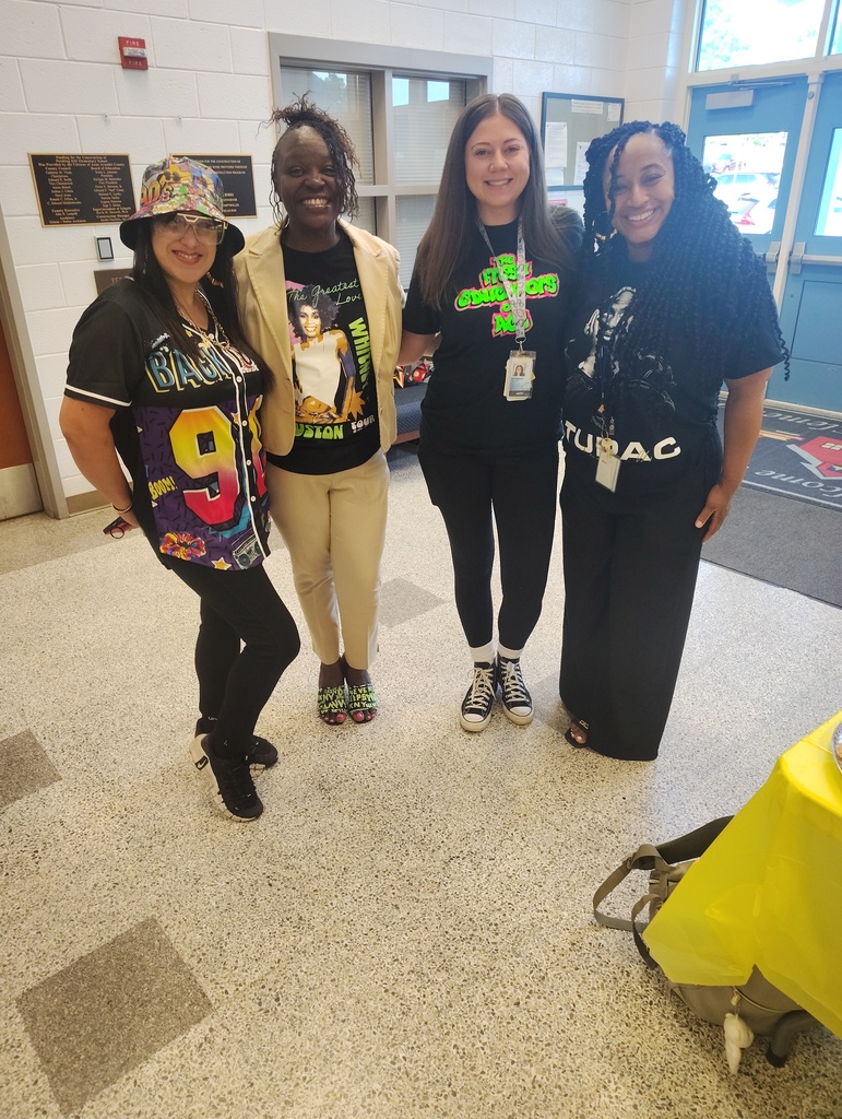 4 staff members posing for a picture in 90s gear