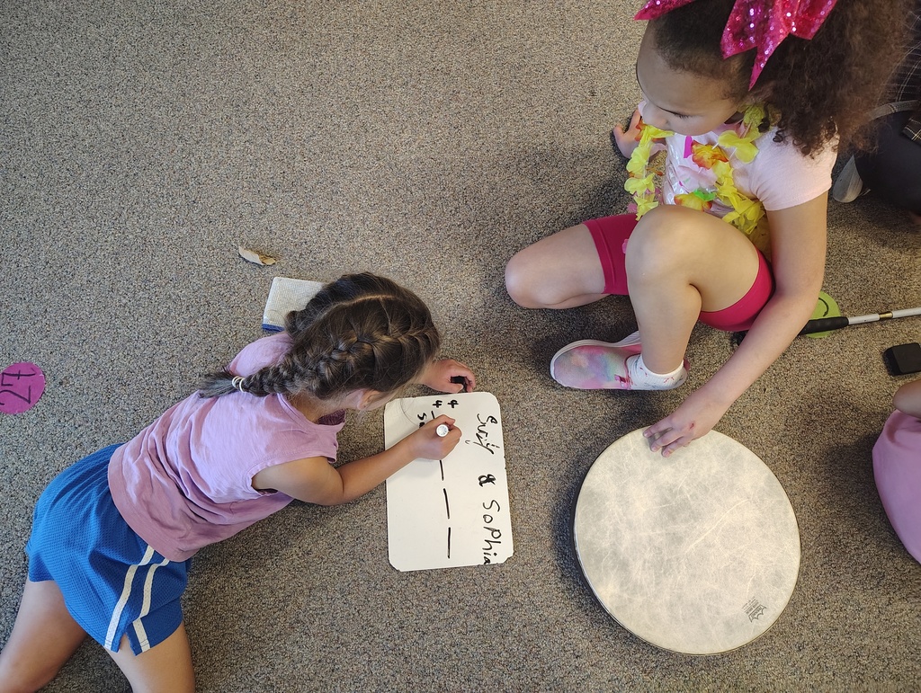 2 students, a white board, and a drum