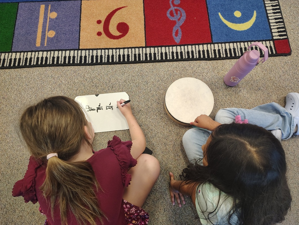 2 students, a white board, and a drum