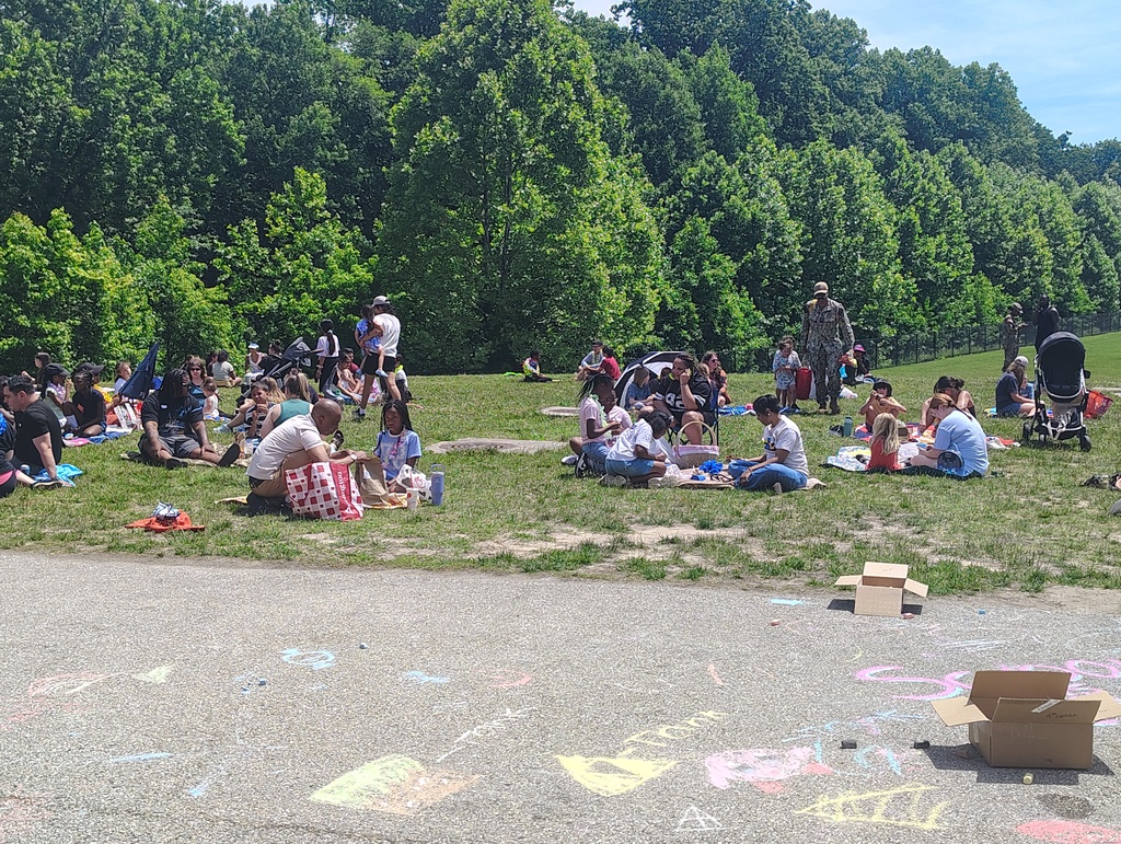 students and families eating picnic style