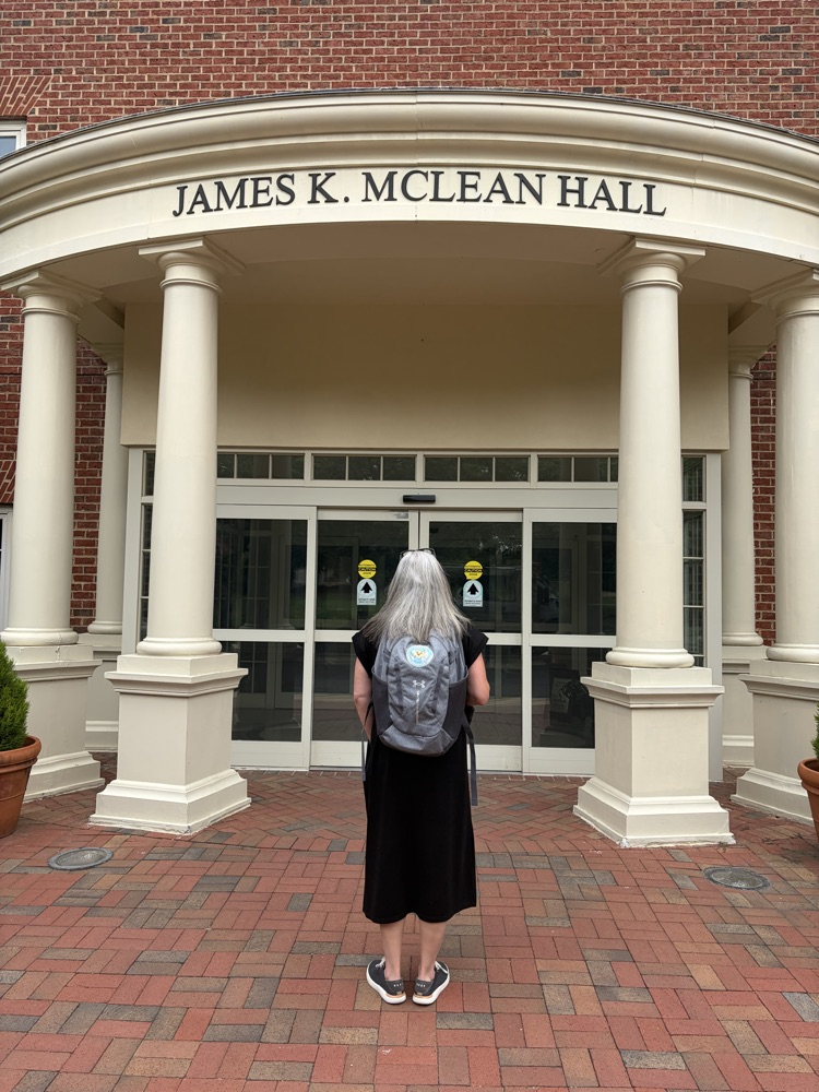 Principal Hamlin standing in front of a building at the University of North Carolina Chapel Hill wearing a Carver backpack