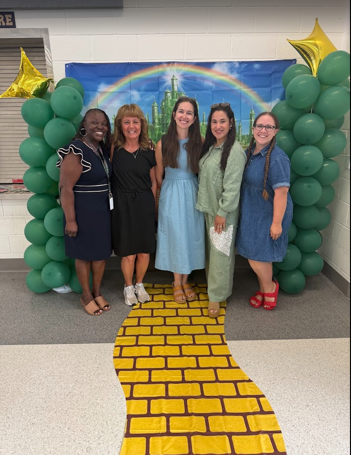 5 female educators standing on a yellow brick road