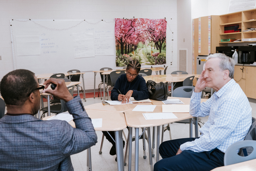 AACPS Mentoring Conference 2026: Three people seated at a table in a classroom. 