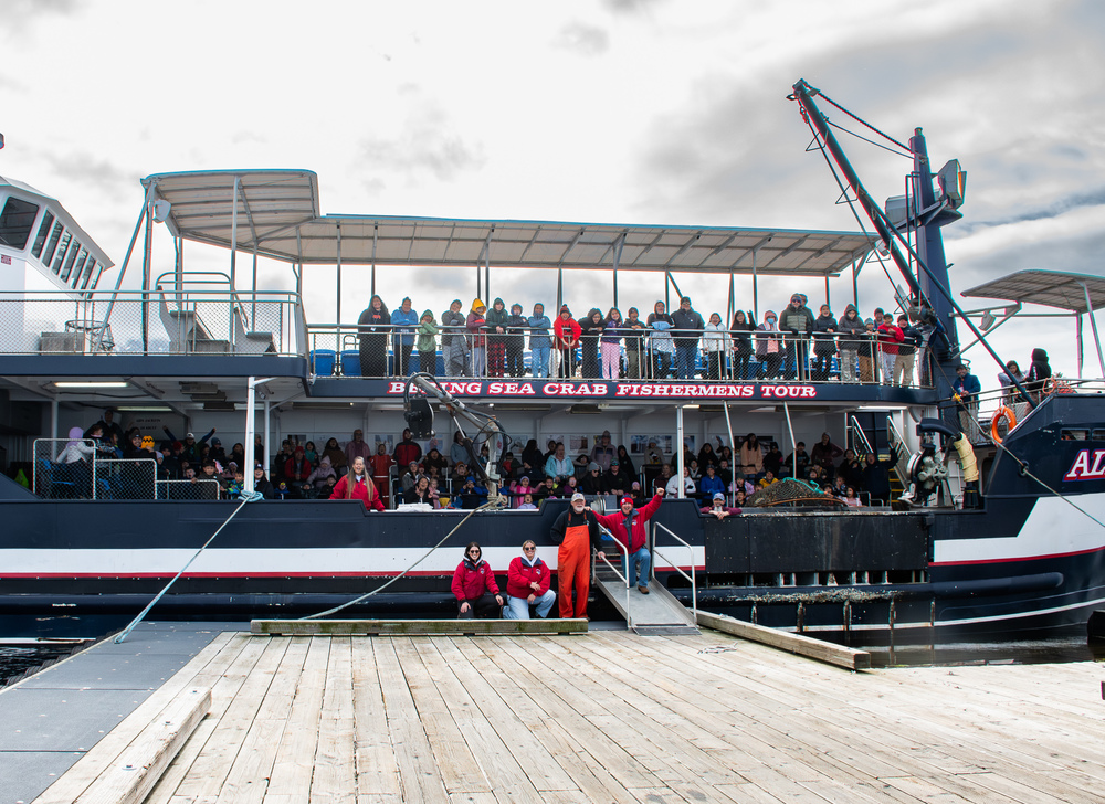 large crabbing boat with students and teachers on it.  There is a second story with additional students standing on it.
