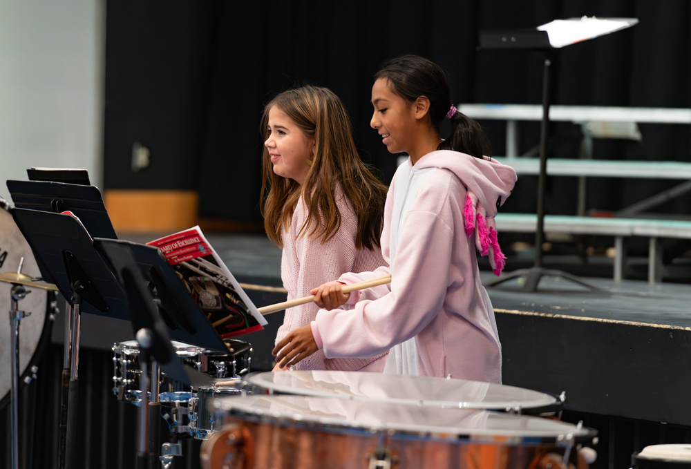 students in costumes playing drums