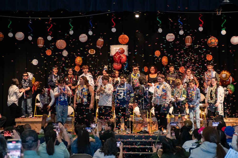 students on stage with confetti and sports themed decorations