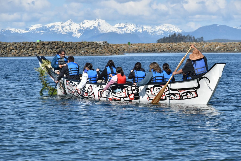 people kayaking in large boat