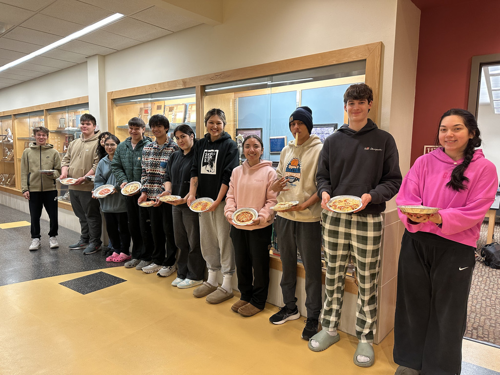 students in hall holding pizza