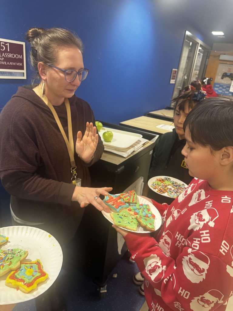 students making holiday cookies - giving them to teacher