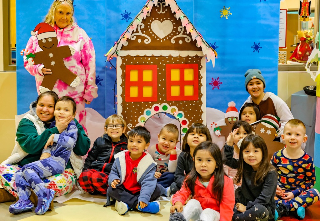 students in front of gingerbread house