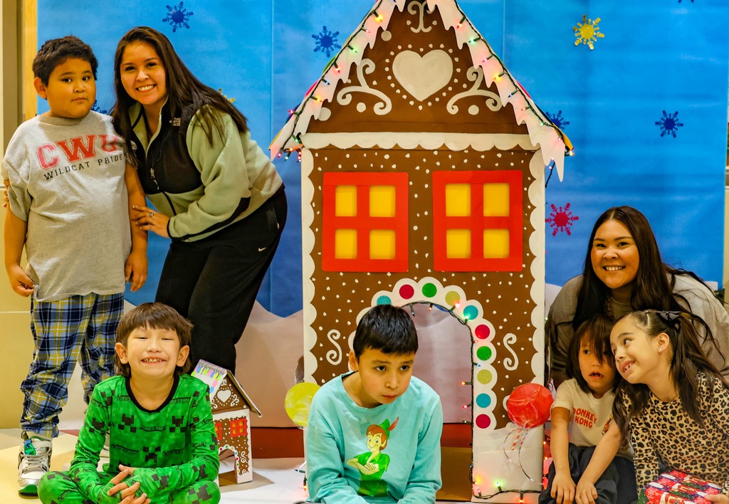 students in front of gingerbread house