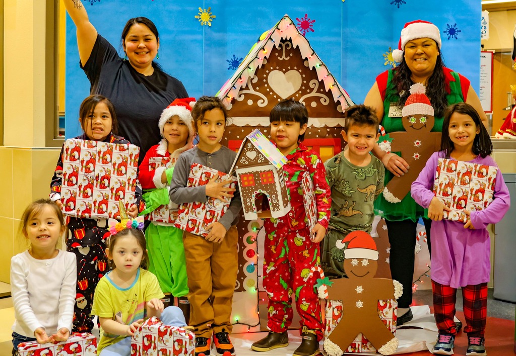 students in front of gingerbread house