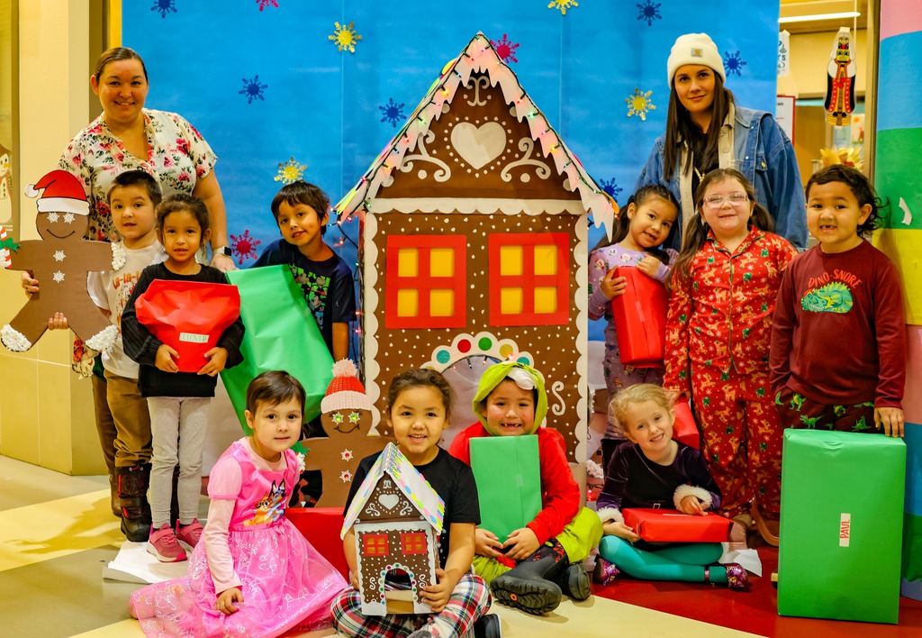 students in front of gingerbread house