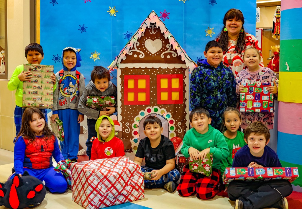 students in front of gingerbread house