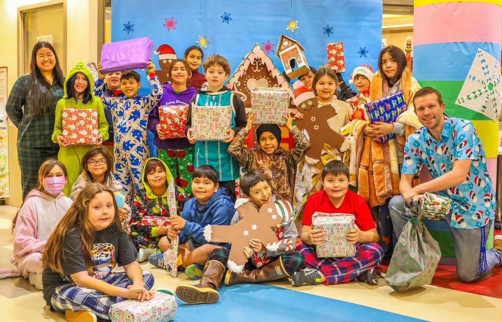 students in front of gingerbread house