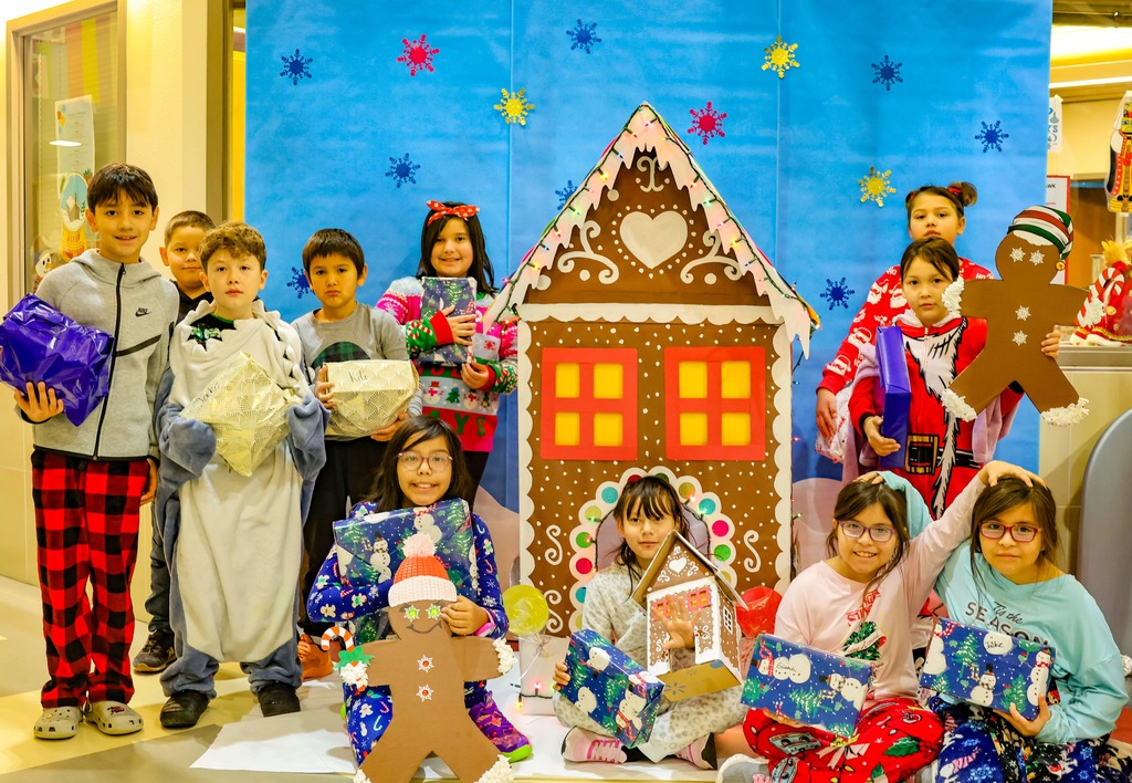students in front of gingerbread house