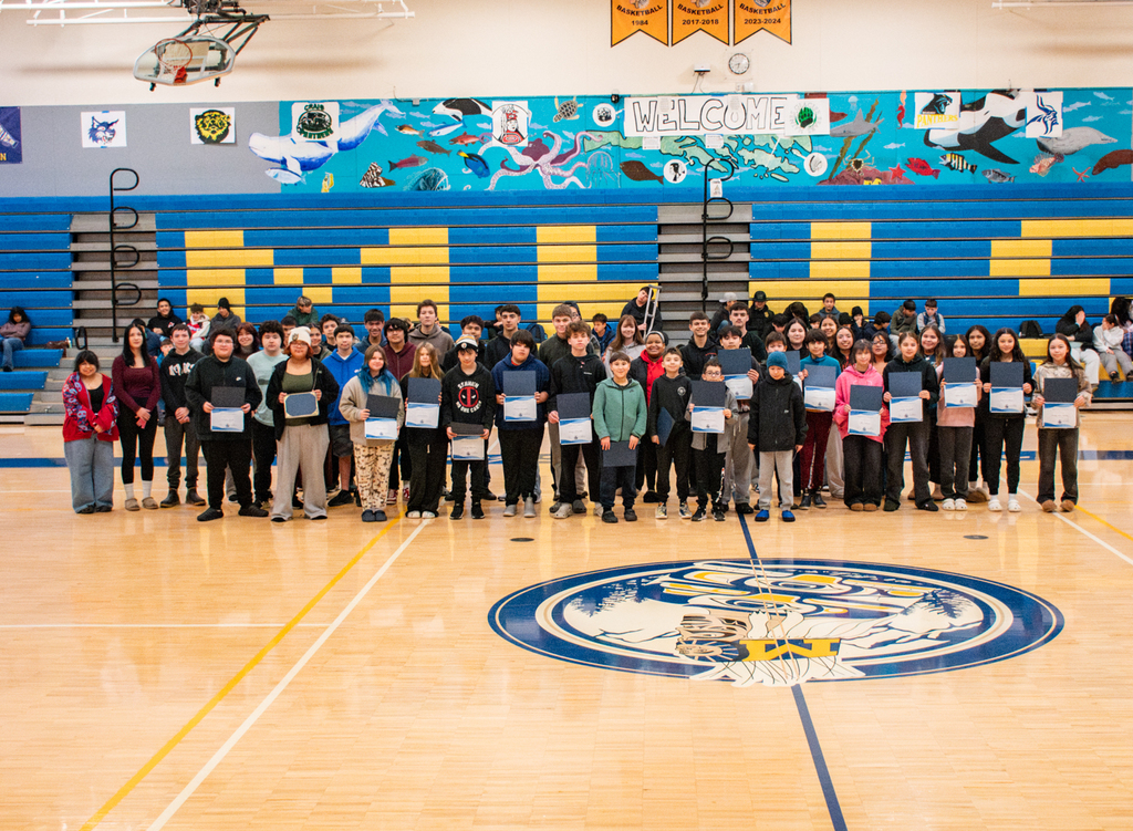 students in gym holding certificates